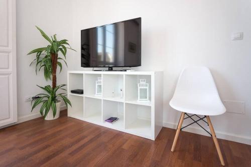 - un centre de divertissement blanc avec une télévision et une chaise blanche dans l'établissement Sunny Málaga Apartments, à Malaga