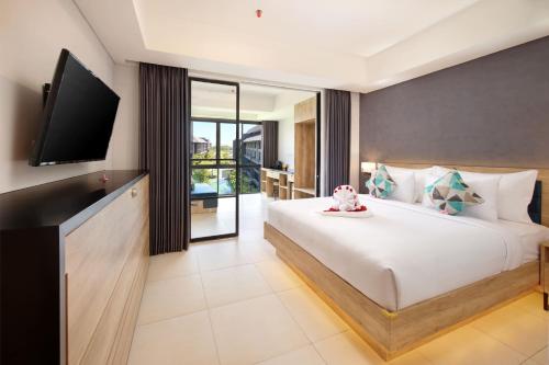 a bedroom with a large bed with a flat screen tv at Anagata 2 Tanjung Benoa Bali in Nusa Dua