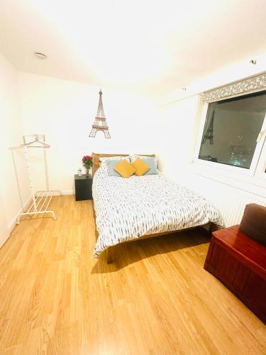 1 dormitorio con 1 cama y suelo de madera en K court , 18 en Londres