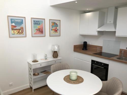 une cuisine avec une table blanche et un comptoir blanc dans l'établissement Gîte Fort César, à Wissant