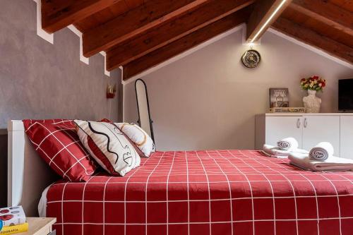 a room with a bed with a red plaid blanket at Alex Haus in Somma Lombardo