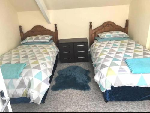 two beds sitting next to each other in a bedroom at Cosy 2 Bedroom Apartment near Seafront in Penzance