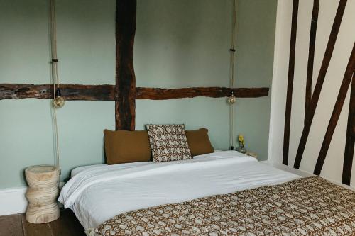 a bedroom with a bed with white sheets at Mercerie de Denise in Le Bourg-Dun