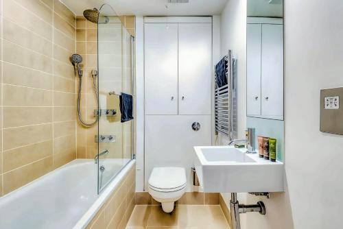 a bathroom with a toilet and a sink and a tub at Welcome London - Maddox in London