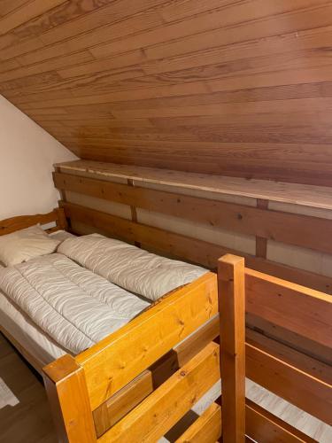 un lit dans une chambre avec un plafond en bois dans l'établissement Triplex pieds des pistes st lary Soulan, à Saint-Lary-Soulan