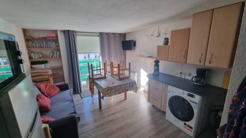 un salon avec une cuisine et une salle à manger dans l'établissement Triplex pieds des pistes st lary Soulan, à Saint-Lary-Soulan