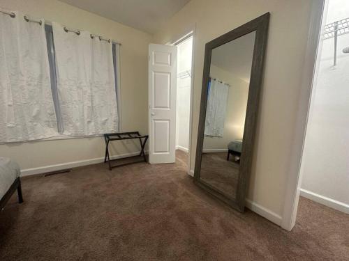 a room with a mirror and a bed and a window at Great Value Close to Proctors Gorgeous Townhouse in Schenectady