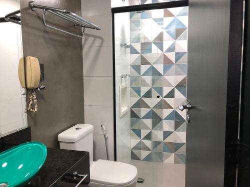 a bathroom with a toilet and a glass shower at Quarto de hotel entre os Shoppings Vila Olimpia e JK Iguatemi in Sao Paulo