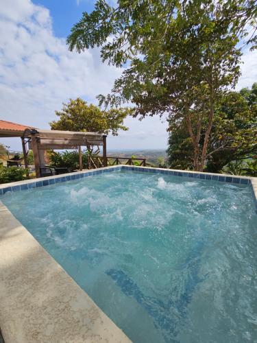 una piscina de agua azul y un banco en Casa Neblinas, en San Carlos