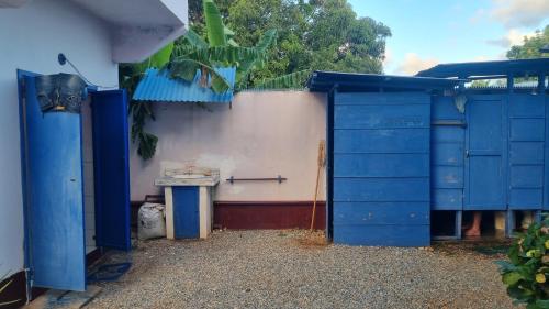 a blue building with a sink and a blue door at Il Triangolo Hostel in Las Galeras