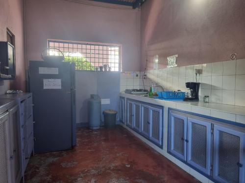 a kitchen with blue cabinets and a blue refrigerator at Il Triangolo Hostel in Las Galeras