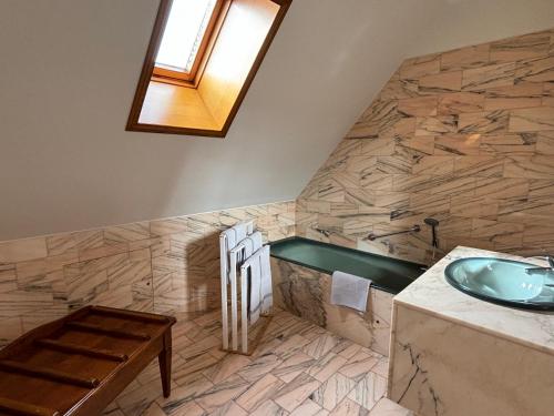 baño con lavabo y mesa de madera en Hotel Le Manasses en Curtil-Vergy