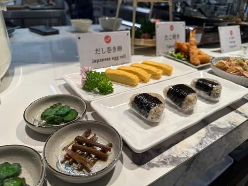 a buffet with different types of food on plates at MOMIZI HANOI 2 - PHAN KE BINH in Hanoi