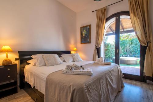アルゲーロにあるRELAIS APARTMENTS - Villa Deseoのタオルが敷かれた大きなベッドのある寝室