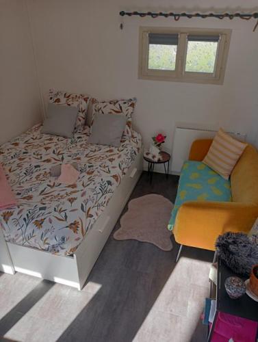 um quarto com uma cama e uma cadeira em Studio Marie em Belbeuf