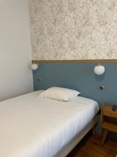 a bed in a room with a blue wall at Le Florus in Montrouge