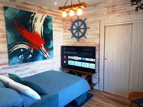 um quarto com uma cama e uma televisão de ecrã plano em Le relais des bains em Paladru