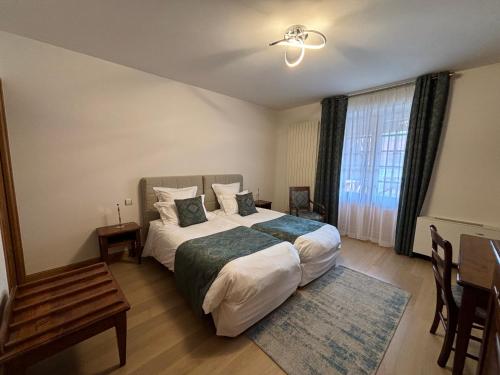 a bedroom with a large bed and a window at Hotel Le Manasses in Curtil-Vergy