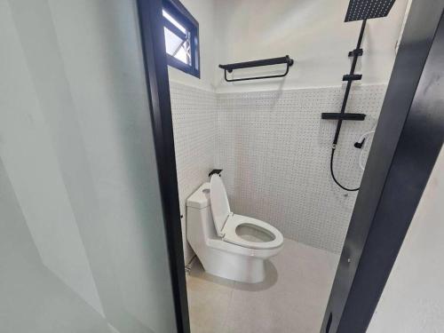 La salle de bains est pourvue de toilettes blanches et d'une fenêtre. dans l'établissement 52PrivateHouse, à Lampang