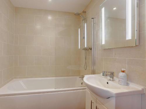 a bathroom with a tub and a sink and a bath tubermottermott at 2 Bed in Launceston BRDEX in Launceston