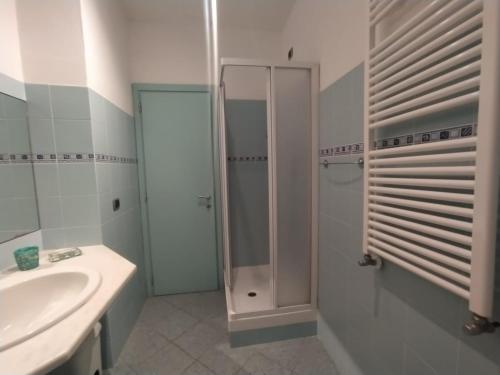 a white bathroom with a shower and a sink at MISTRAL House in Levanto