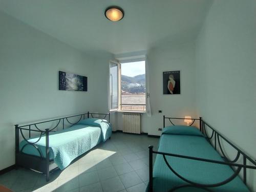 a bedroom with two beds and a window at MISTRAL House in Levanto