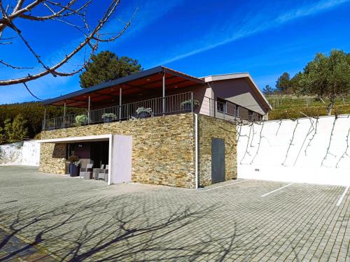 a large brick building with a balcony on top at Quinta Manhas Douro in Provesende
