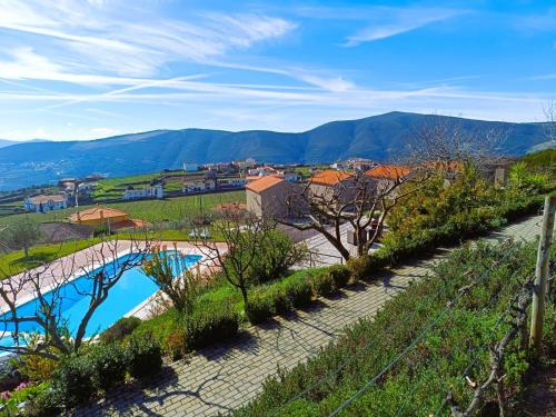 a bridge over a river in a town with mountains at Quinta Manhas Douro in Provesende