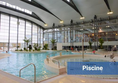 une grande piscine intérieure dans un immeuble dans l'établissement Le Velvet proche aéroport CDG I Paris I Astérix, à Moussy-le-Vieux