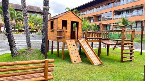 a playground with a wooden play house and a slide at ECO RESORT PRAIA DOS CARNEIROS in Tamandaré