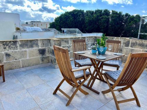 a wooden table and chairs on a patio at Rb42 - Charming & Historic House in Rabat