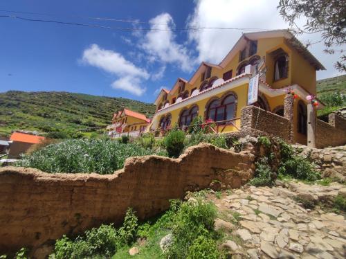 a yellow house on top of a hill at MIRADOR DEL INCA in Isla de Sol
