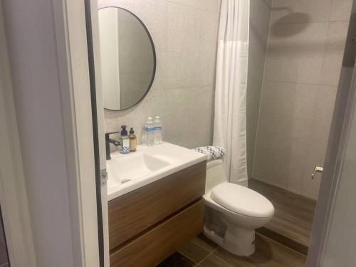 a bathroom with a sink and a toilet and a mirror at Céntrico, muy cómodo y agradable. Con gran vista in Tijuana