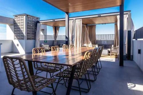 a wooden table and chairs on a balcony with a table at Céntrico, muy cómodo y agradable. Con gran vista in Tijuana