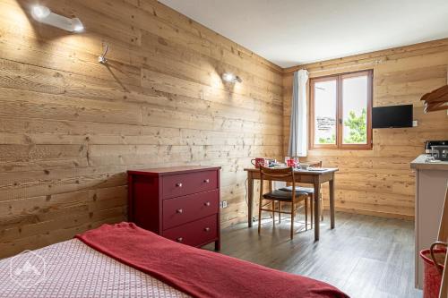 1 dormitorio con paredes de madera, mesa y cama en Côté-Bourget 2 personnes L'AIGUILLE D'ORAN proche La Norma Aussois !, en Villarodin-Bourget