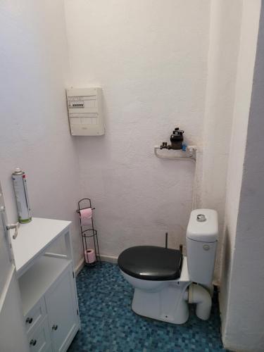 een badkamer met een toilet en een zwarte stoel bij Elégant apparemment 60m2 climatisé in Avignon