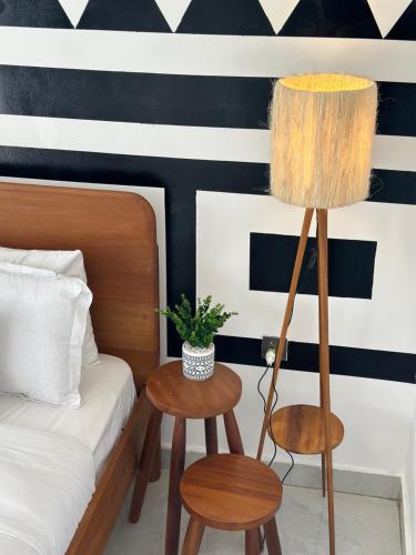a bedroom with a bed and two tables and a lamp at Coalescence Hotel Rwanda in Kigali