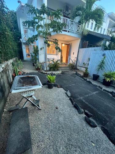 a house with a grill in the middle of a driveway at Maison Sandra Montchoisy in Mont Choisy