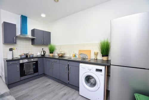 a kitchen with a refrigerator and a washing machine at Manchester city center luxury in Manchester
