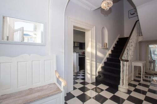 a hallway with a black and white checkered floor at Beautiful Victorian Coastal Holiday Home in Kent