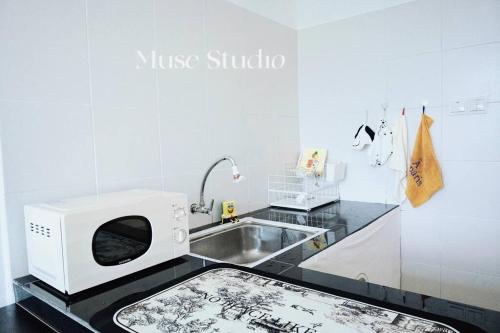 eine Küche mit Mikrowelle und Spüle in der Unterkunft Muse Studio @CBD with pool in Gua Musang
