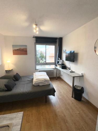 une chambre avec un lit, un bureau et une fenêtre dans l'établissement Studio Paisible Cœur de Paray-Le-Monial app 303, à Paray-le-Monial