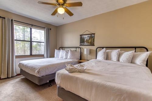 a bedroom with two beds and a ceiling fan at Pool- Pinecrest Townhomes-1King-2Queen Unit-Updated in Pigeon Forge