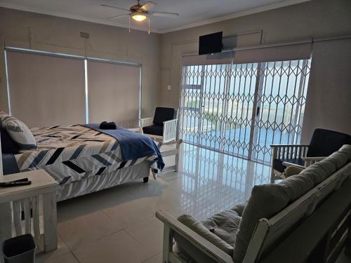1 dormitorio con 1 cama y balcón con piscina en Engel, en Struisbaai
