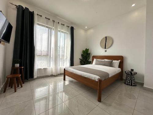 a bedroom with a bed and a large window at Coalescence Hotel Rwanda in Kigali