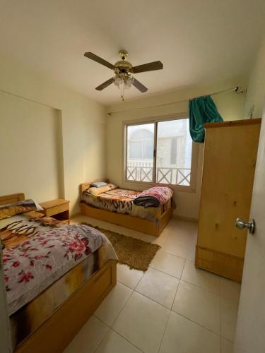 sypialnia z 2 łóżkami i wentylatorem sufitowym w obiekcie شقه بالغردقه w mieście Hurghada