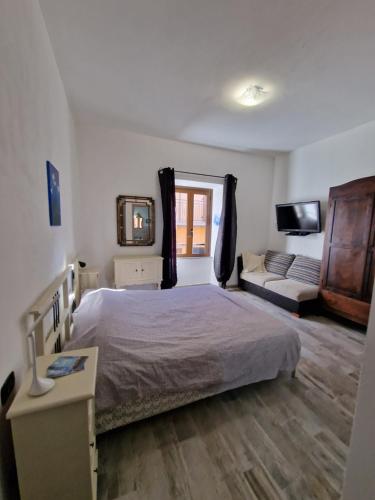 um quarto com uma cama, uma televisão e um sofá em La Barabbata em Marta
