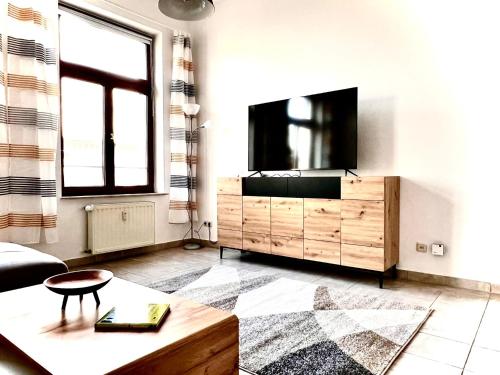 una sala de estar con TV de pantalla plana en una cómoda en City Central Hegelstraße, en Magdeburgo