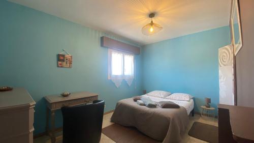 une chambre bleue avec un lit et une fenêtre dans l'établissement Le Panache, à Sevremont
