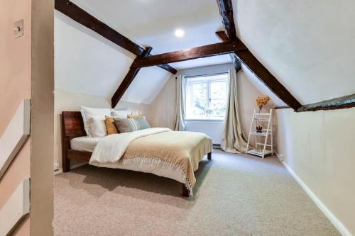 a bedroom with a bed and a window at The Loft @ The Old George Inn in South Cerney